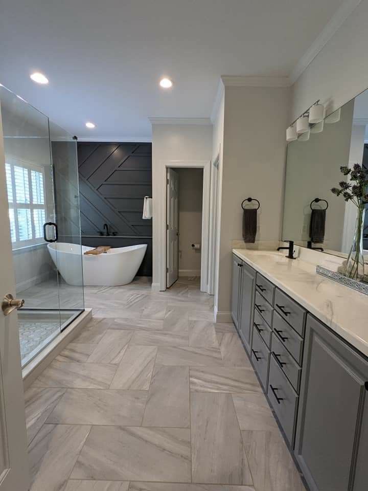 Renovated primary bathroom with freestanding tub and herringbone tile floor in Vaughan