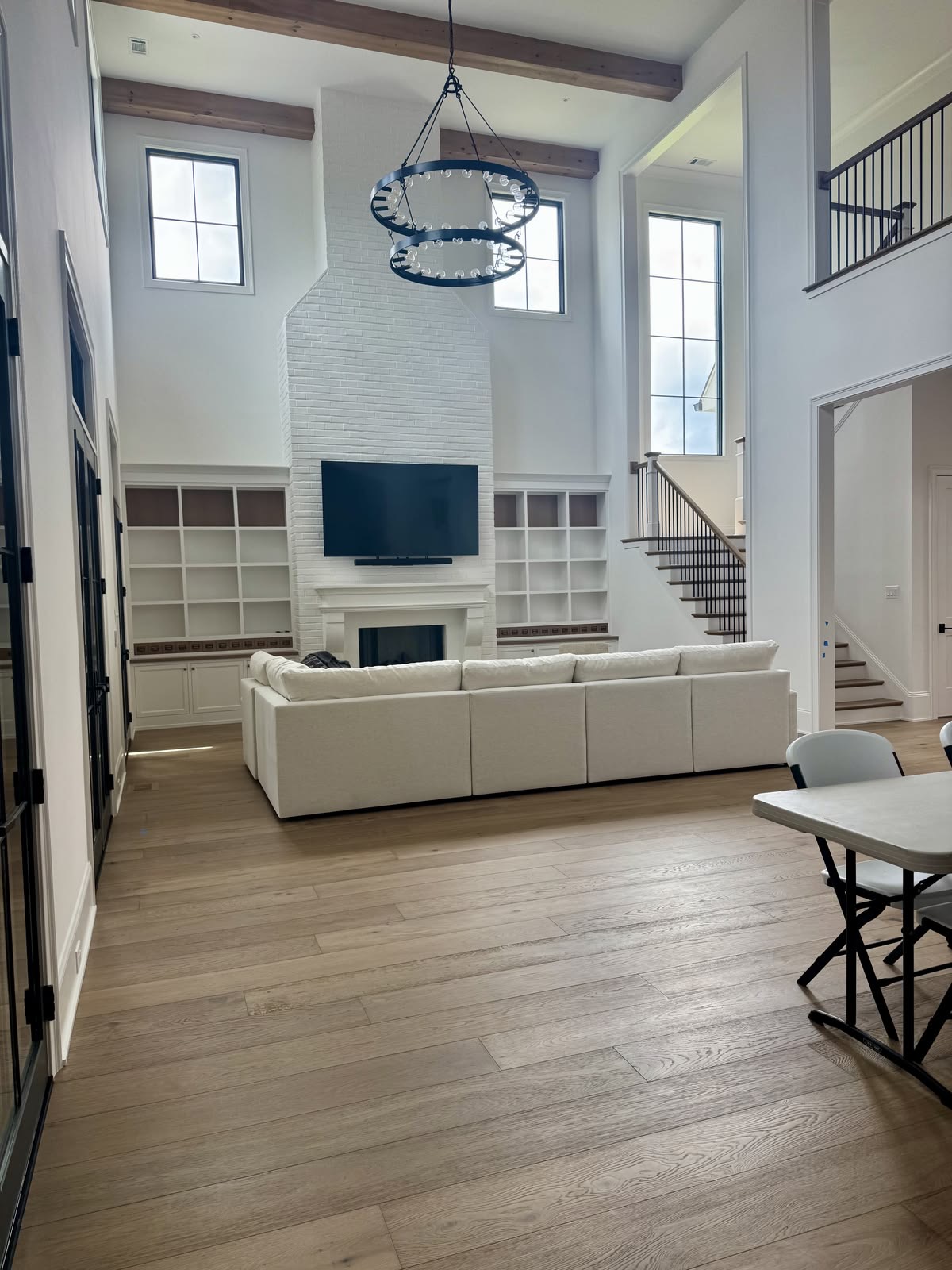 Renovated great room with white brick fireplace and built-in shelving in Vaughan